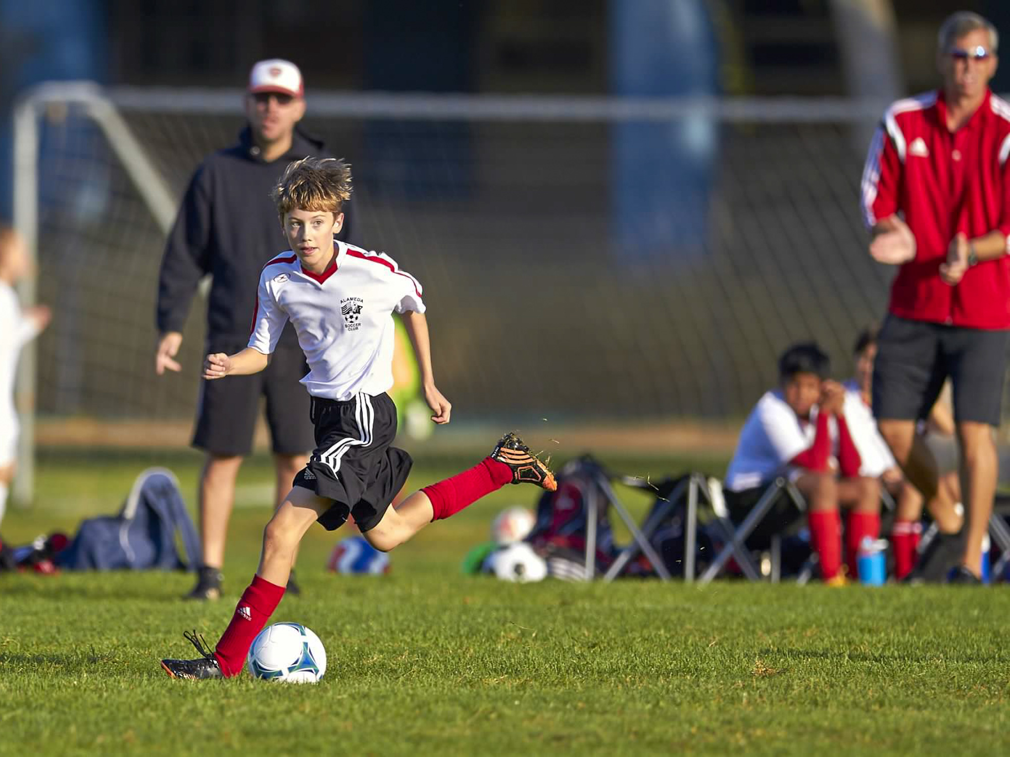 boy looking to pass, coaches applauding in background