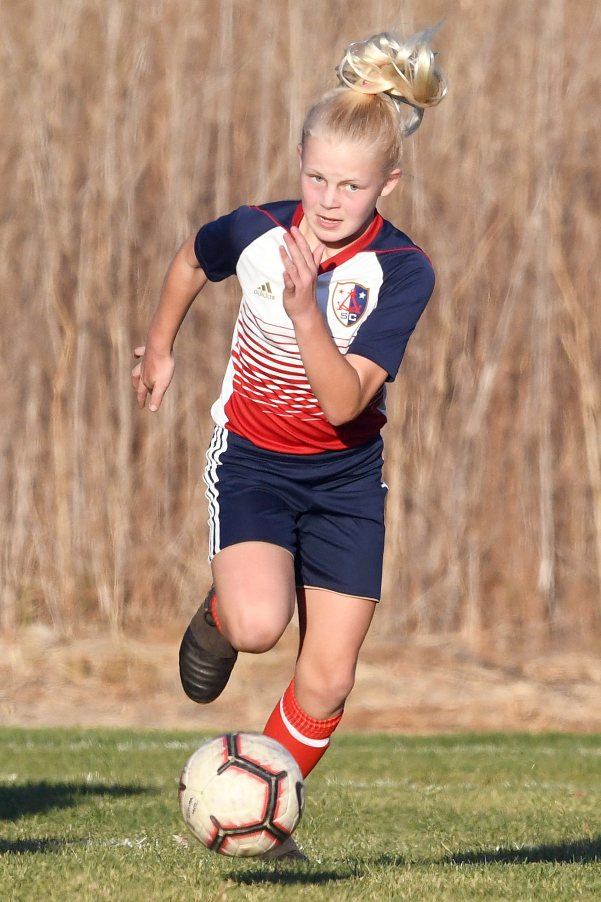 girl sprinting after the ball