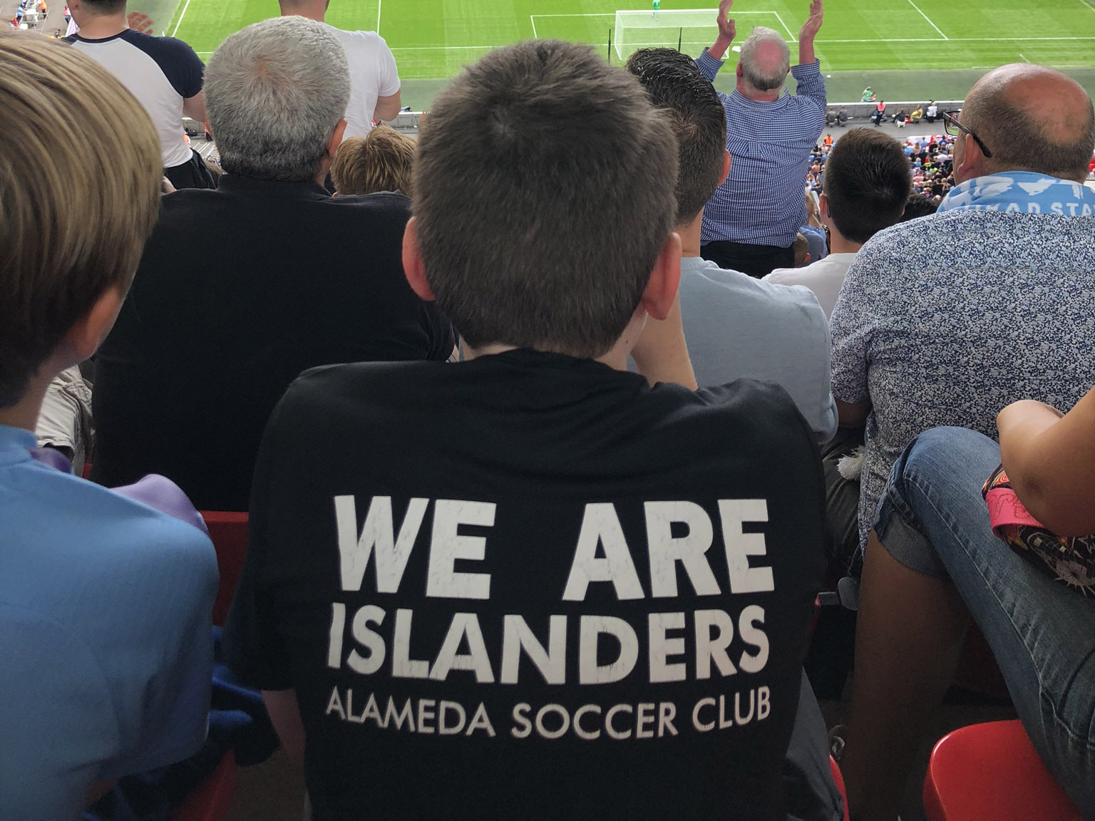 boy wearing T-Shirt saying We Are islanders watching a game