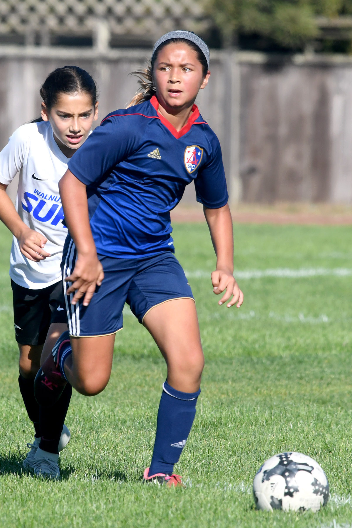 girl dribbling ball looking up for someone to pass to